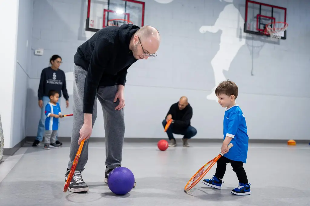 Kid playing sports with an adult.