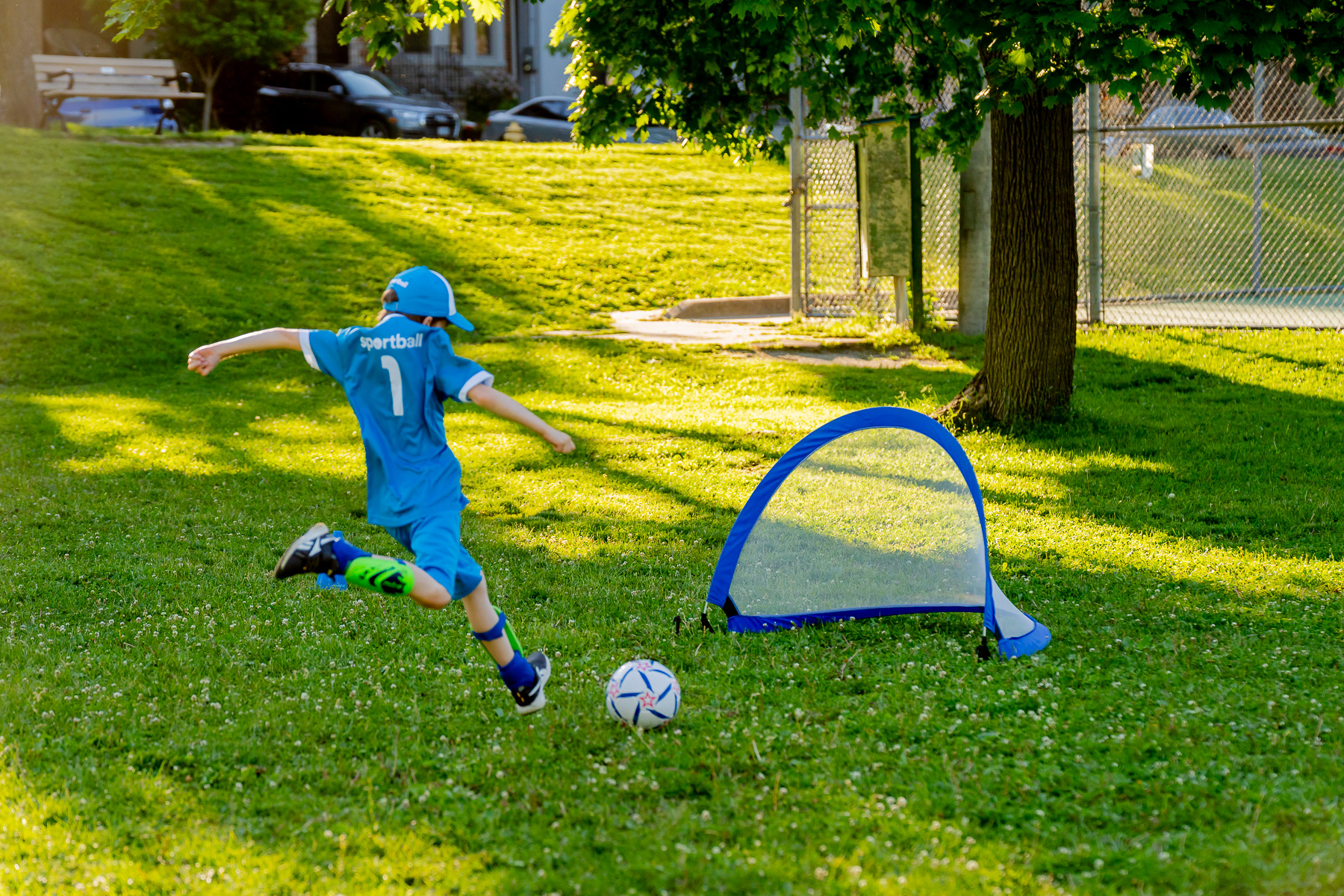 Child kicks soccer ball into net